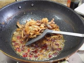 下入炸好的鸡肉，与香料混合，干煸入味