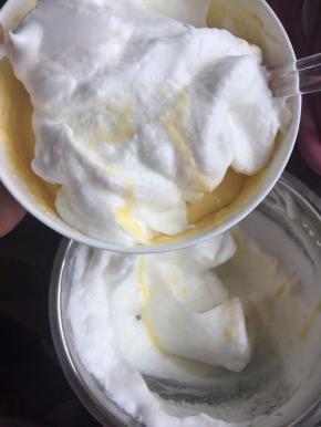 然后取1/2蛋白霜到蛋黄液中用刮刀切拌