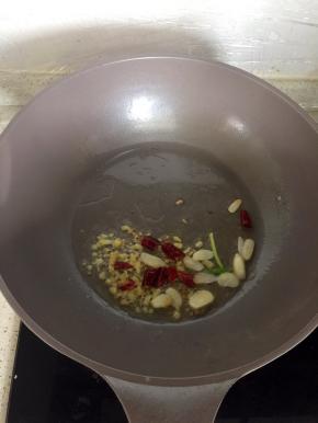 锅里倒适量油小火煸香姜蒜辣椒。