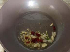 锅里倒适量油小火煸香姜蒜辣椒。