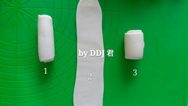再重复擀一遍。。拿起一个卷儿，擀成长舌状，再由上至下卷起