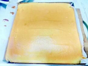 烘烤结束取出烤盘轻摔一下，把蛋糕卷连同油纸移至晾网架上，轻轻撕去油
纸，再虚盖在蛋糕上。(如果是正卷的话，就是正面向上，反卷就是贴油纸的那面向上。)
