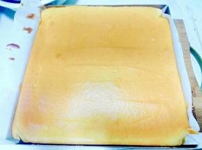 烘烤结束取出烤盘轻摔一下，把蛋糕卷连同油纸移至晾网架上，轻轻撕去油
纸，再虚盖在蛋糕上。(如果是正卷的话，就是正面向上，反卷就是贴油纸的那面向上。)
