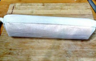 用擀面杖反卷起油纸，在起头轻压一下顺势卷起蛋糕卷，直到卷完蛋糕卷，抽出擀面杖放一边静止定型。

