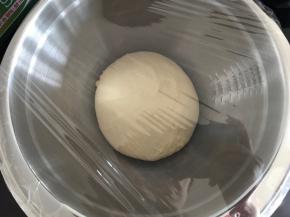 将面团从面包桶取出，整成团，放进干净的盆里，盖上保鲜膜进行第一次发酵。因为现在室温很高，我是直接室温进行发酵。