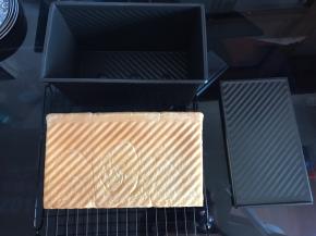 出炉后拉开土司盒盖子，将土司盒在烤架上轻震一下，倒出吐司晾凉。