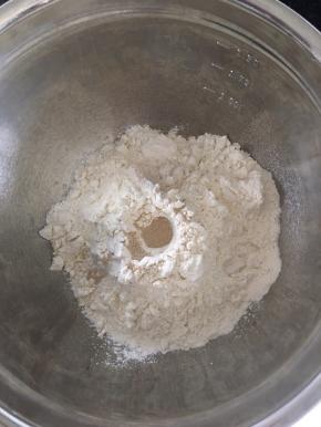 盆里称好面粉，加入糖盐，中间挖个孔倒入酵母。