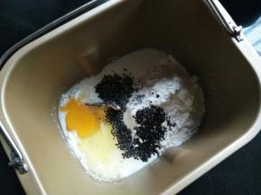 鸡蛋、牛奶、麻薯粉和黑芝麻倒入面包桶