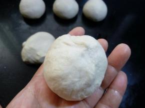 取一块切割后的面团，用光滑的一面去包住分割时的碎块，在面团的底部捏紧捏实，有点像们平时包包子的那样。
 
