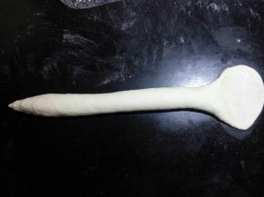 左手边一端稍微搓细一点，另 一端用手掌压扁后擀面杖将其擀薄擀宽。
 

