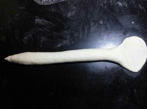 左手边一端稍微搓细一点，另 一端用手掌压扁后擀面杖将其擀薄擀宽。
 
