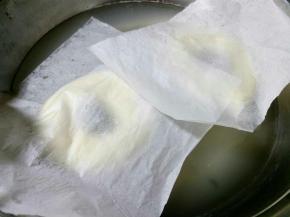 将发酵好的面团取出，用手托着连油纸一起放进糖水，油纸自然会掉落。(因为贝果底部可能会粘，如果直操拽下来，会导致变形，而且面团易塌掉，这也就是一定要放在油纸上的原因。)