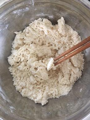 倒入水，水最好不要一下子倒进去，慢慢倒慢慢用筷子搅拌，搅拌成絮状无明显干粉即可！