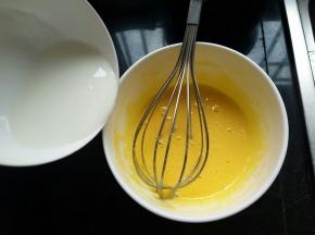 牛奶加热立马倒入蛋黄里，要沿着边缘慢慢倒入，手动打蛋抽快速的搅打均匀（热牛奶慢慢倒入，快速搅打）