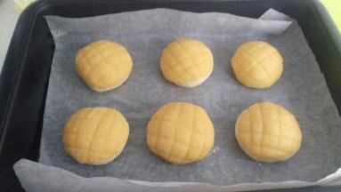 把酥皮压扁，盖在面团上面。盖住整个面包。