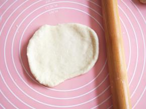 将松弛好的面团擀成长舌状，从一端卷起