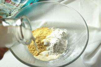 玉米面、小麦粉、酵母和白糖放进盆内，加入牛奶。