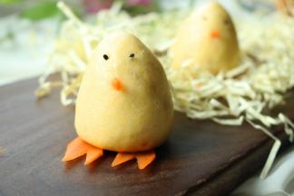 用胡萝卜做出脚丫子和嘴巴，黑芝麻当眼睛，装饰一下，萌哒哒的小鸡就做好了。