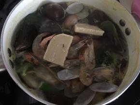 然后加入贝类小虾和奶块煮至沸腾即可