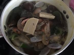 然后加入贝类小虾和奶块煮至沸腾即可