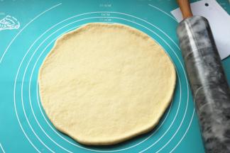 发酵好的面团，排出其中的大气泡，静置一小会后团擀成薄片，比披萨盘略大。