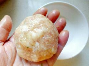 将拌好的肉分成几份，两手蘸生粉水后，逐份放在手掌中，用双手来回翻动，交替接着肉圆，滚成表面光滑。
 
