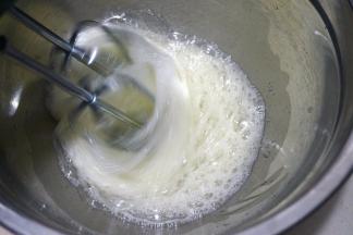 60克红糖分三次放入蛋白糊中，第一次，用电动打蛋器中速将蛋清打出粗泡