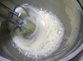 60克红糖分三次放入蛋白糊中，第一次，用电动打蛋器中速将蛋清打出粗泡