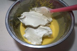 将三分之一蛋白糊入蛋黄糊中，用硅胶刮刀从下向上翻拌均匀