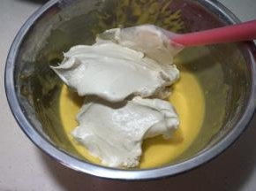 将三分之一蛋白糊入蛋黄糊中，用硅胶刮刀从下向上翻拌均匀