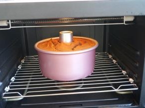 蛋糕回落，与模具持平，出炉，立即端起模具轻轻震几下，将蛋糕内部多余的热气震出，然后倒扣在晾架上