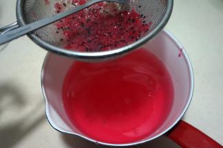 将火龙果果酱放在筛网中，再浸入糖水中，用小勺轻轻搅拌，使大果肉和籽留在筛网上，弃之不用