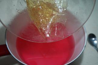 将火龙果糖水液重新坐在火上，煮开后，将泡软的吉利丁片放入其中，搅拌至融化