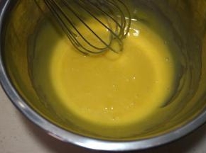 蛋黄中加入20克白糖、玉米油，用手动打蛋器混合均匀