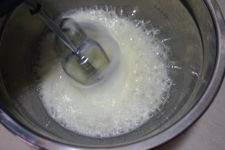 60克白糖分三次放入蛋白糊中，第一次，用电动打蛋器中速将蛋清打出粗泡