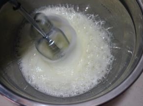 60克白糖分三次放入蛋白糊中，第一次，用电动打蛋器中速将蛋清打出粗泡