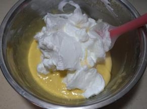 将三分之一蛋白糊入蛋黄糊中，用硅胶刮刀从下向上翻拌均匀