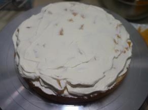 取一片蛋糕，先抹一层奶油，再铺上橙子丁，再抹一层奶油，扣上一层蛋糕片