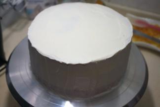 依次完成，奶油薄厚自己来掌握，顶部的奶油抹平后，将周边的奶油刮平整，呈裸蛋糕状