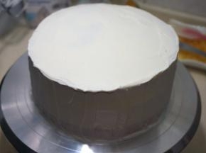 依次完成，奶油薄厚自己来掌握，顶部的奶油抹平后，将周边的奶油刮平整，呈裸蛋糕状
