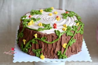 适量淡奶油加可可粉，打成纹路状，用刮刀随意在蛋糕外层做出粗糙树皮状，再用加绿色色素的淡奶油挤出树藤状，点缀成小花朵