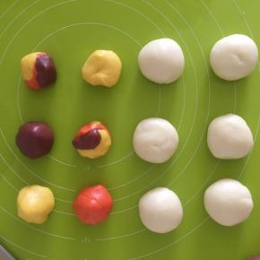 油酥的面粉量分为3份，分别加入红曲粉和南瓜粉，另一份加入南瓜粉与红曲粉的混合，在分别加入猪油，揉成团即可。水油皮分成一个大概34g的面团，油酥分为22g一个的面团，可以把三种颜色混合，看自己喜好搭配。共6个水油皮面团，6个油酥面团。