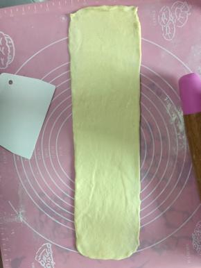 擀成长舌状，卷起放入吐司盒中