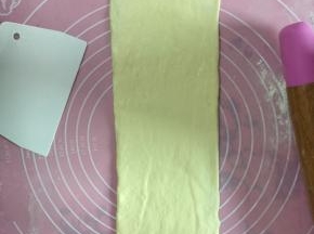 擀成长舌状，卷起放入吐司盒中