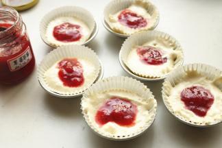 纸膜内加入蛋糕糊，中间挖出洞，倒入一些果酱。