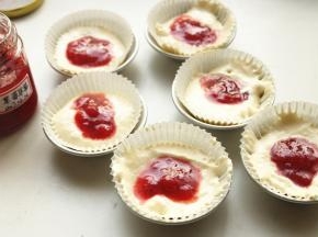 纸膜内加入蛋糕糊，中间挖出洞，倒入一些果酱。