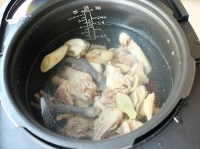 干净的鸡块放进苏泊尔鲜呼吸电压力锅内，并加入姜片和葱段。