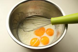 玉米油和牛奶混合，加入10克白糖，搅匀到差不多白糖融化，液体乳化状态。鸡蛋蛋白蛋黄分离，蛋黄加入到牛奶玉米油中。