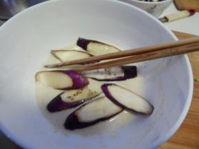 搅拌好的面糊加入腌好的茄子