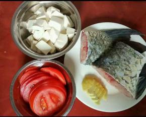 鱼尾分成两段，豆腐切小块，番茄和姜切片